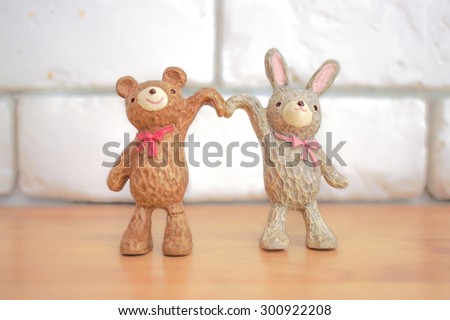 Soft Focus of Ceramic Bear and Rabbit Raising Hands in heart shape, Soft Focus on Rabbit, Blur Background, Love and Happiness Concept [Original Collection]