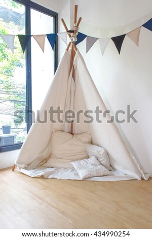 Playroom for kids with Teepee or DIY tent, decorated flags. Window Lights. Soft Focus. Slightly grained filter.