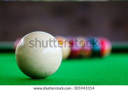 Placement of billiard balls on the table before the game. Focus on white ball.