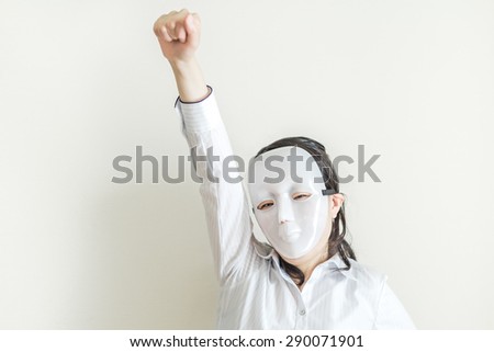 Asian woman wearing white mask striking victory pose