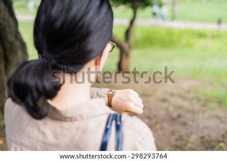 Asian woman looking at her watch