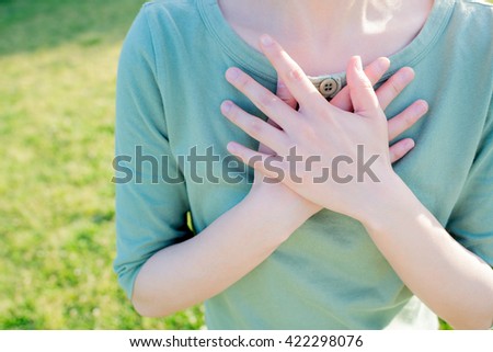 Asian woman putting her hands on the chest