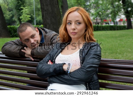 Young man and woman angry and conflicting on a park bench