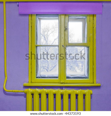Old yellow wooden window and radiator in a purple room. Winter scenery outside