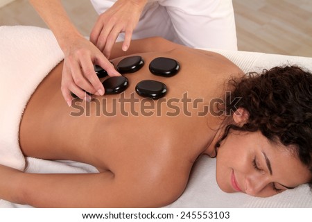 woman relaxing while a hot stone massage