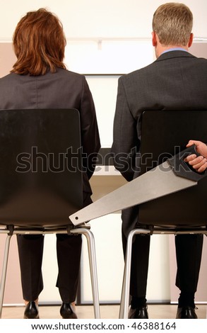 colleges sitting next to each other and the man is holding a saw