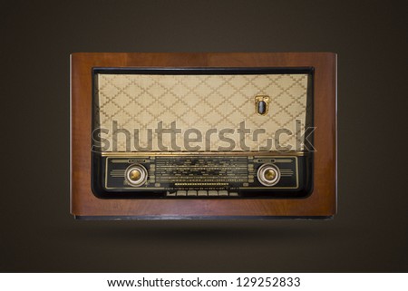Picture of an old vintage, wooden radio isolated on brown background with noise.