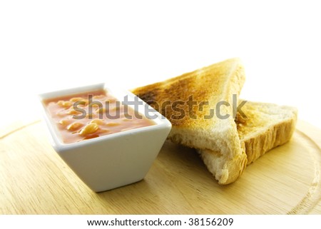Delicious cooked breakfast items with toast and baked beans on a plate on a white background