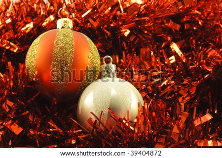 Shiny silver and red round baubles on red tinsel background