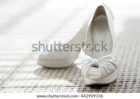 White elegant bridal shoes on the floor