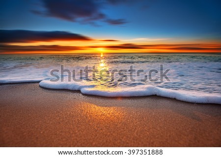 Sunrise light shining on ocean waves.
