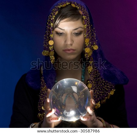 Gypsy fortuneteller uses a crystal ball to foretell the future - stock photo