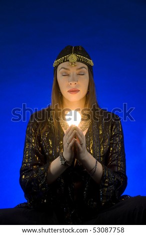 Gypsy with light sits in meditation