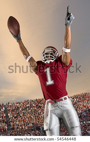 Football player celebrates after scoring a touchdown. Vertical shot.