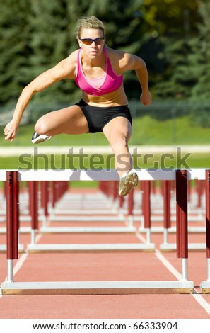 Female track and field athlete hurdling.