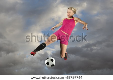Female soccer player kicking a ball in midair.