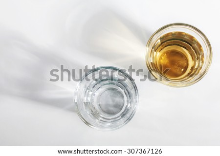 Top view of two shot glasses of Brazilian gold cachaca isolated on white background