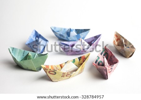 A group of brazilian bills folded to sailboats. Origami art. Money from Brazil.