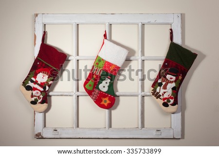 Handmade Santa boots hang on a rustic window frame