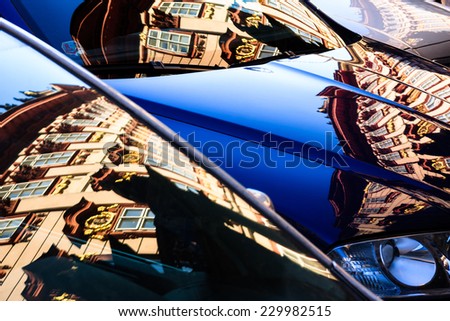 Old building of School of Philosophy, Charles University, reflected on clean cars parked in the street, Praha, Czech Republic