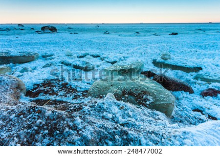 Sea shore with rocks and ice blocks after snow storm on Gulf of Finland, Russia