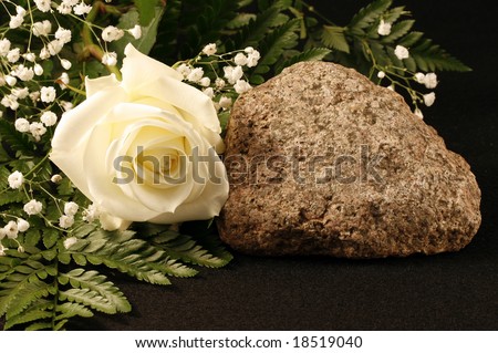 White rose, rock, fern and babies breath with room for copy,