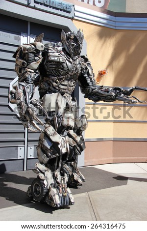 Los Angeles, California, USA - March 12, 2015: The Impersonator of Transformers movie is welcoming tourists in front of the Transformers Ride at Universal Studios Hollywood.