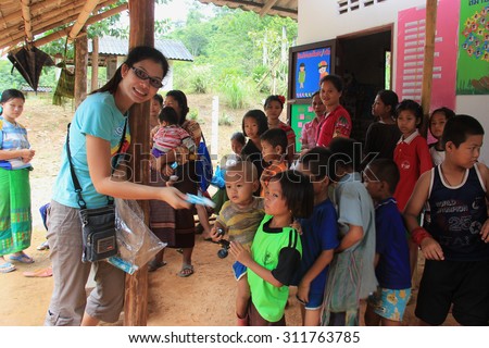 Kanchanaburi, Thailand - July 21, 2013: Poor children line up to get donated stuffs from volunteers.