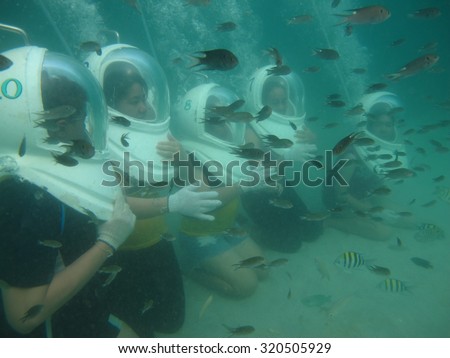 Chonburi, Thailand - February 2, 2012: Seawalkers are playing with fish under the sea in Thailand.