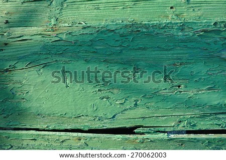 Old green wooden boat hull with paint peeling off. Backgrounds and textures