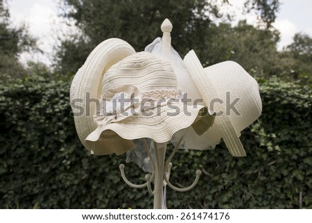 straw hat on a coat rack in a garden. vintage image