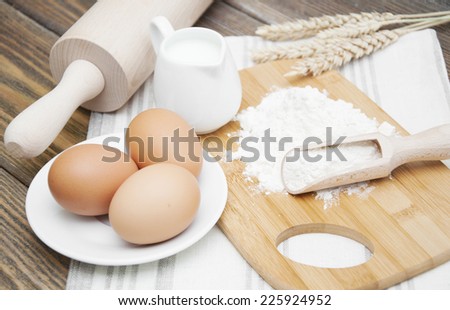 Bread Ingredients - flour, eggs,wheat and milk on a wooden background