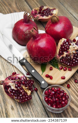 Juicy pomegranate and red grains on wooden background
