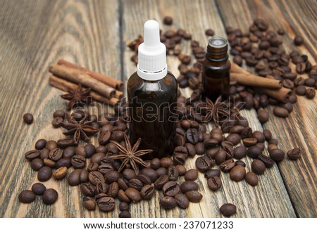 Essential aroma oil with coffee and spices on wooden background