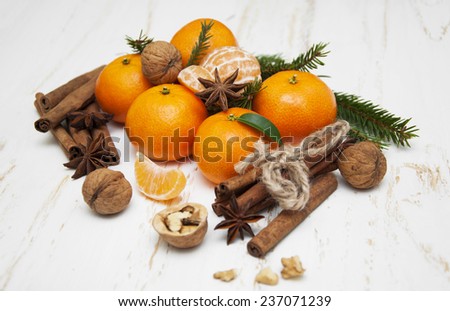 Christmas composition with fresh mandarin oranges, cinnamon, anise, walnuts on old wooden background
