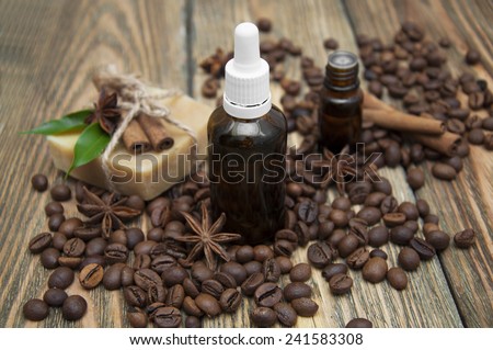 Essential aroma oil and handmade soap with coffee and spices on wooden background