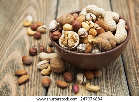 Mixed nuts in a bowl on a wooden background