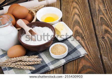 Ingredients for baking. Flour, eggs, butter, sugar, milk on wooden background