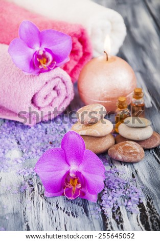 Spa composition with  spa accessories, orchid flowers and towels on a wooden background