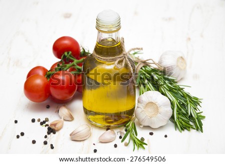 Olive oil, cherry tomatoes, garlic and rosemary on a white wooden background