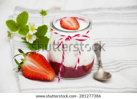 Strawberry yogurt with fresh strawberries on a wooden background