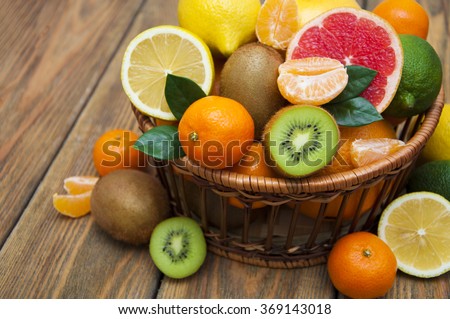 Fresh juicy citrus fruits in a basket on a wooden background