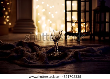 Beautiful two glasses of champagne standing on the table in the background of a blurred room with a decorated Christmas tree and fireplace. Soft focus.