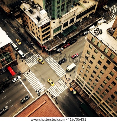 Looking down on to the streets of New York City with New York yellow taxis and people crossing the street going to work. Instagram style image.