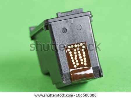 Black cartridge for a printer over a green background