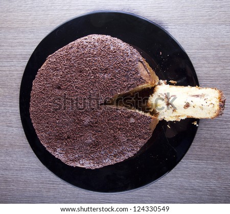 View from above of a chocolate cake with a cut slice
