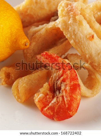Fish fry over white plate, with lemon, close up