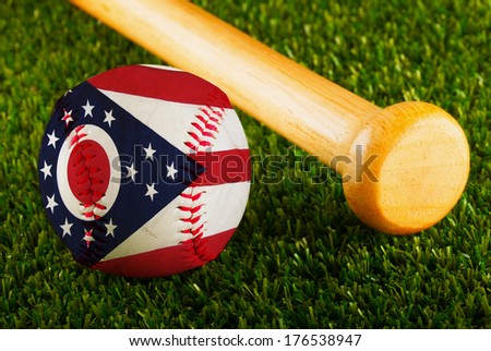 Baseball with Ohio flag and bat over a background of green grass