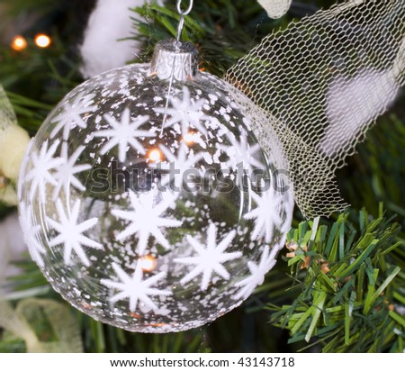 White glass Christmas ball shot in a tree