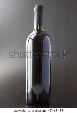A bottle of black wine over black background